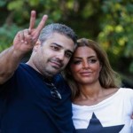 الصحافي في الجزيرة الكندي محمد فهمي يرفع شارة النصر والى جانبه زوجته