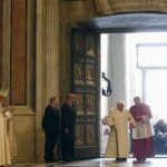 البابا فرنسيس - الى اليسار - فيما البابا السابق بينيديكتوس السادس عشر يعبر الباب المقدس أمس. (رويترز)